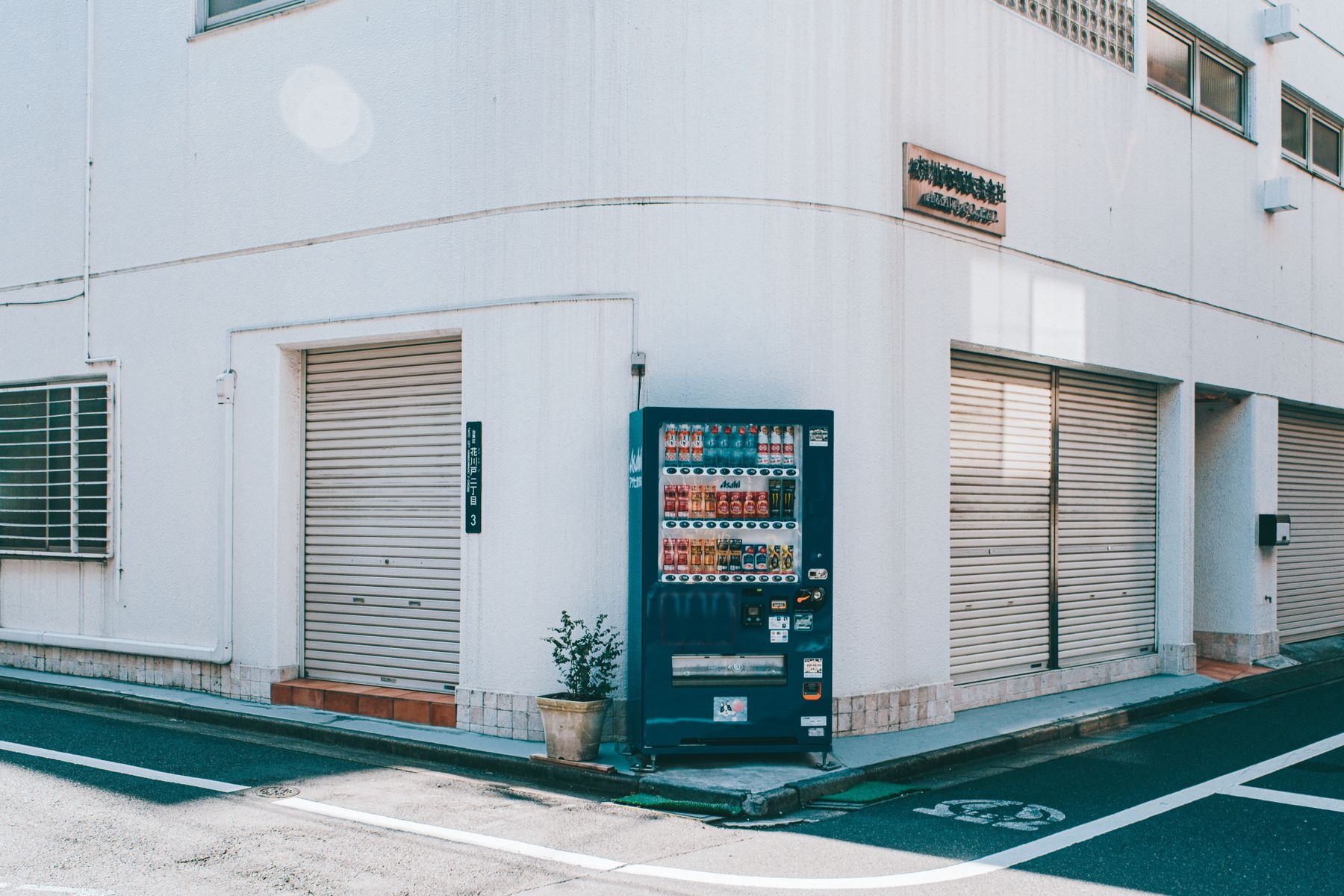 A beverage vending machine on a quiet street corner