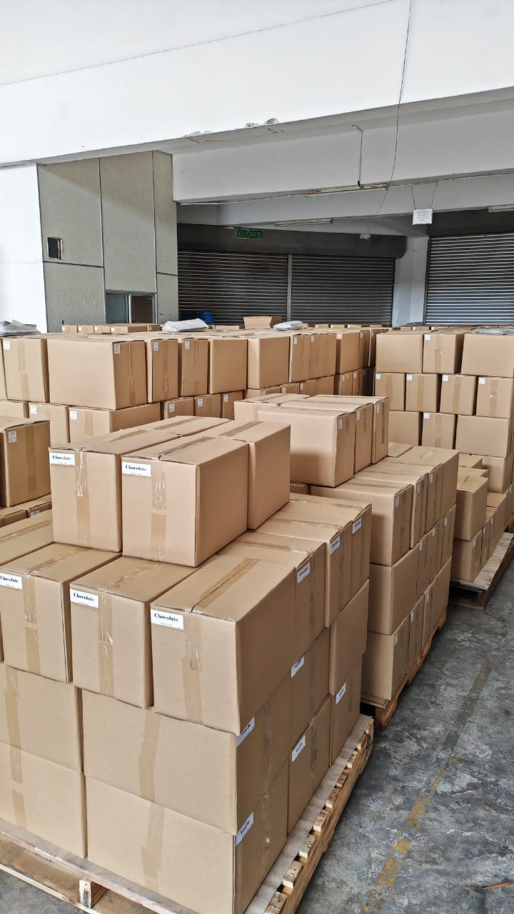Completed batches of cartoned premix powder staged on the warehouse floor for despatch