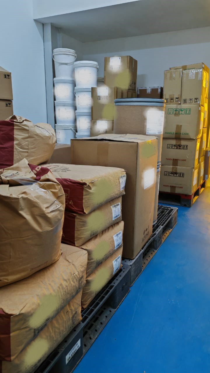 Sacked raw material, pails and cartons staged on pallets in the Beyond Lohas store