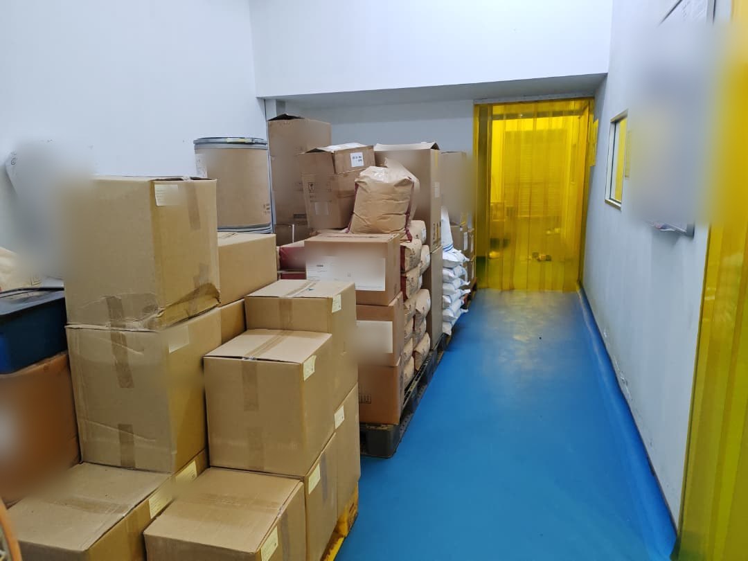 Cartons and palletised stock along the goods corridor leading to the packing room